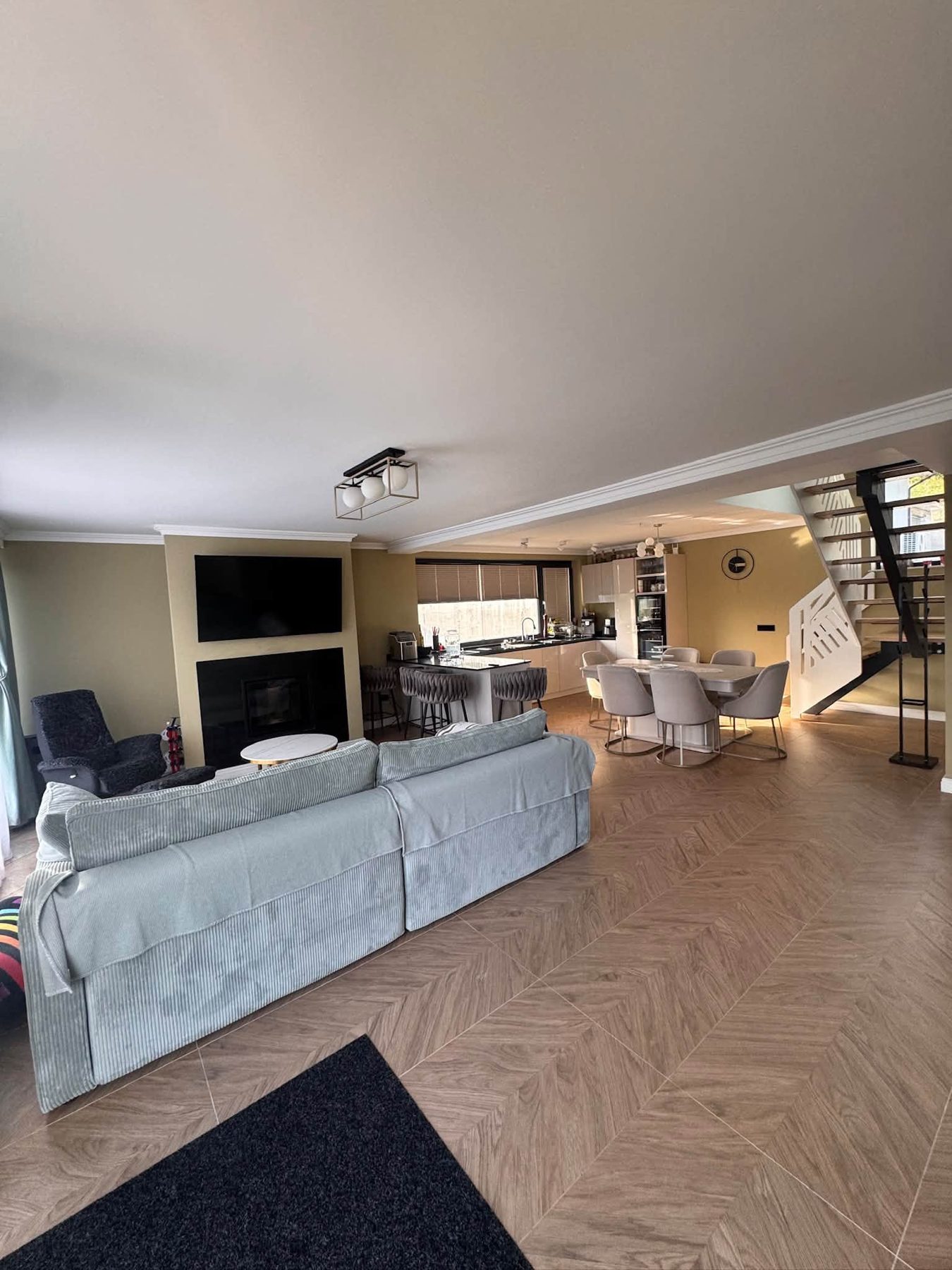Living open-space cu șemineu, bucătărie și zonă de dining